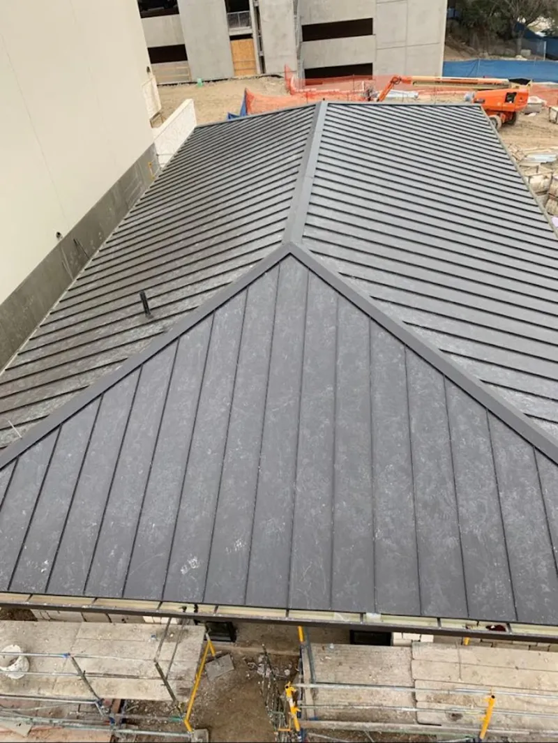 Commercial metal roof construction with crane equipment in Waipio Acres